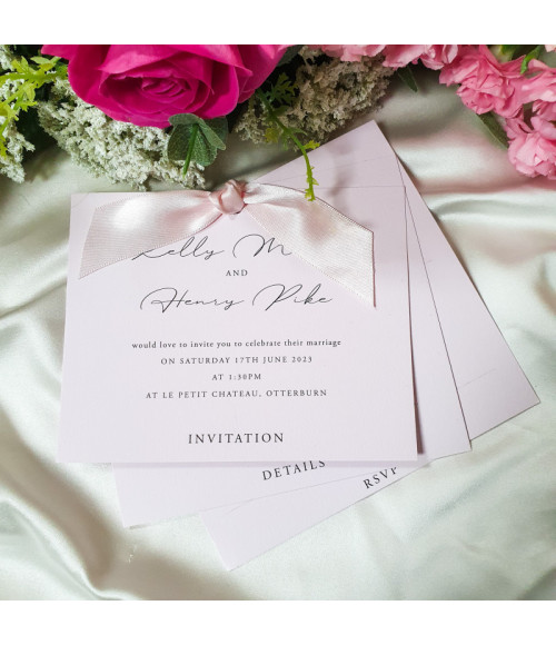 Luxury soft pink wedding stationery with elegant script typography