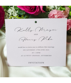 Close-up of blush pink satin ribbon on smooth soft pink wedding card