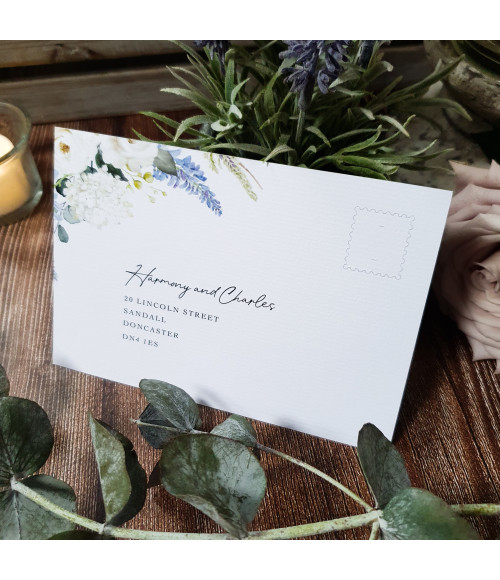 Close-up of dusty blue wedding invitation with textured card and floral detailing