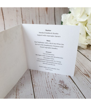 White rose wedding menu opened to display personalised starter, main course and dessert choices for guests.