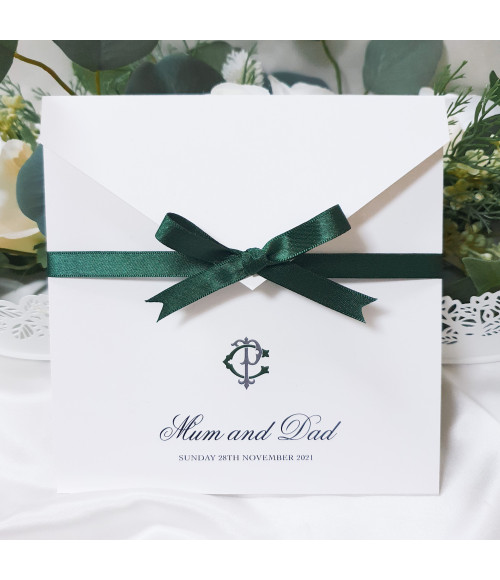 Luxury forest green wedding invitation with satin ribbon bow, personalised monogram and elegant pearl white card folder