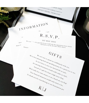 Modern monochrome wedding stationery suite with black ribbon accent and premium presentation design
