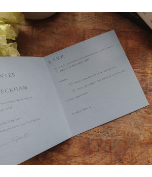 Elegant wedding invitation suite featuring dusty blue tones and refined typography