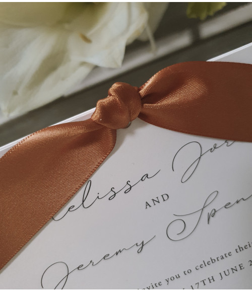 A timeless pearl white invitation wrapped in warm terracotta tones