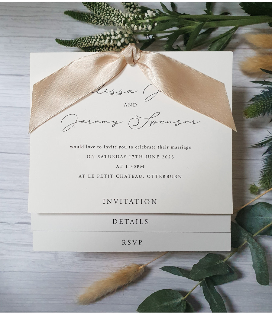 Elegant square wedding invitation with script font, pearl white card, and luxurious sand ribbon accent