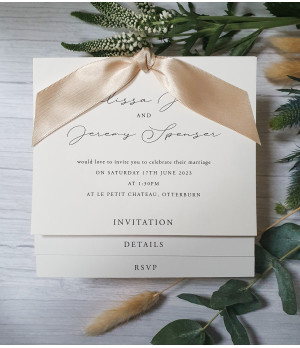 Elegant square wedding invitation with script font, pearl white card, and luxurious sand ribbon accent
