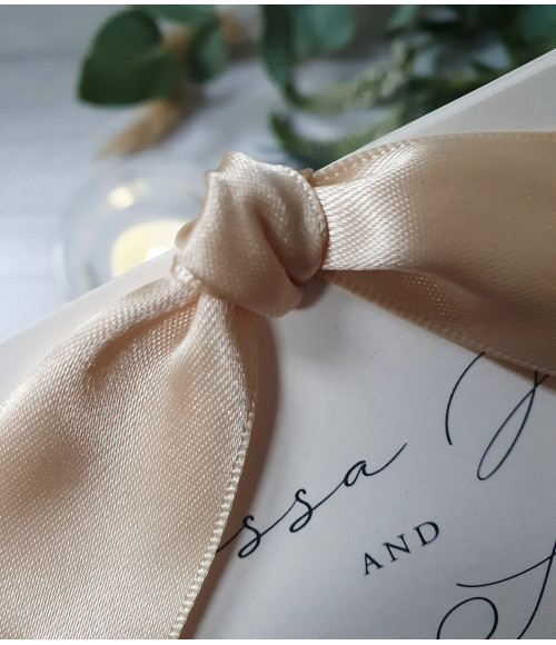 Sophisticated Elegance Sand wedding invitation featuring a pearl white card and sand ribbon