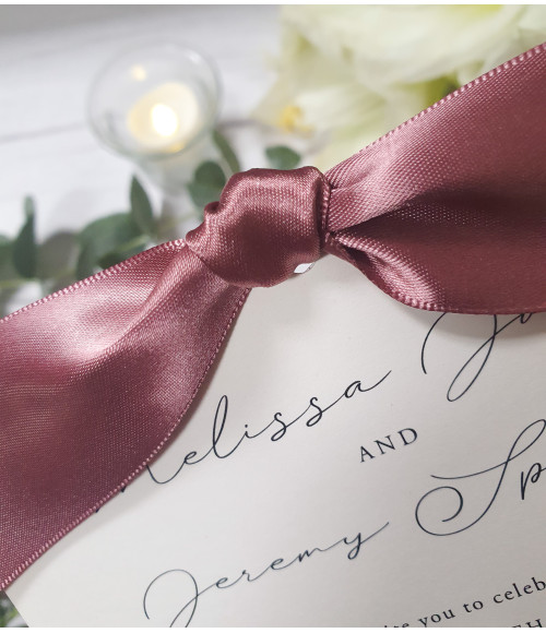 Sophisticated ivory wedding invitation adorned with old rose pink satin ribbon
