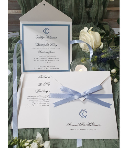 Luxury dusty blue wedding invitation with satin ribbon bow, personalised monogram and elegant pearl white card