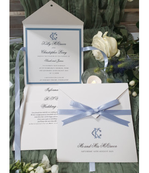 Luxury dusty blue wedding invitation with satin ribbon bow, personalised monogram and elegant pearl white card