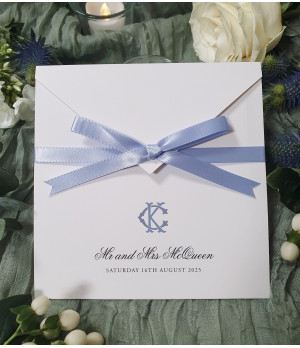 Luxury cornflower blue wedding invitation with satin ribbon bow, personalised monogram and elegant pearl white card