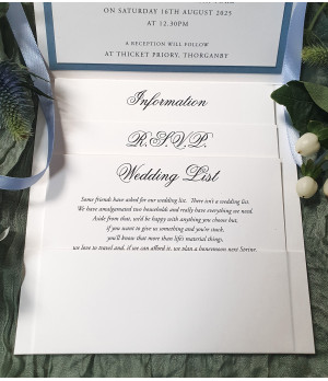 Layered pale blue wedding invitation set with premium inserts and satin ribbon detailing