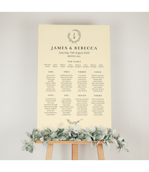 Cream wedding table plan with personalised guest seating and elegant wreath monogram design for wedding reception display