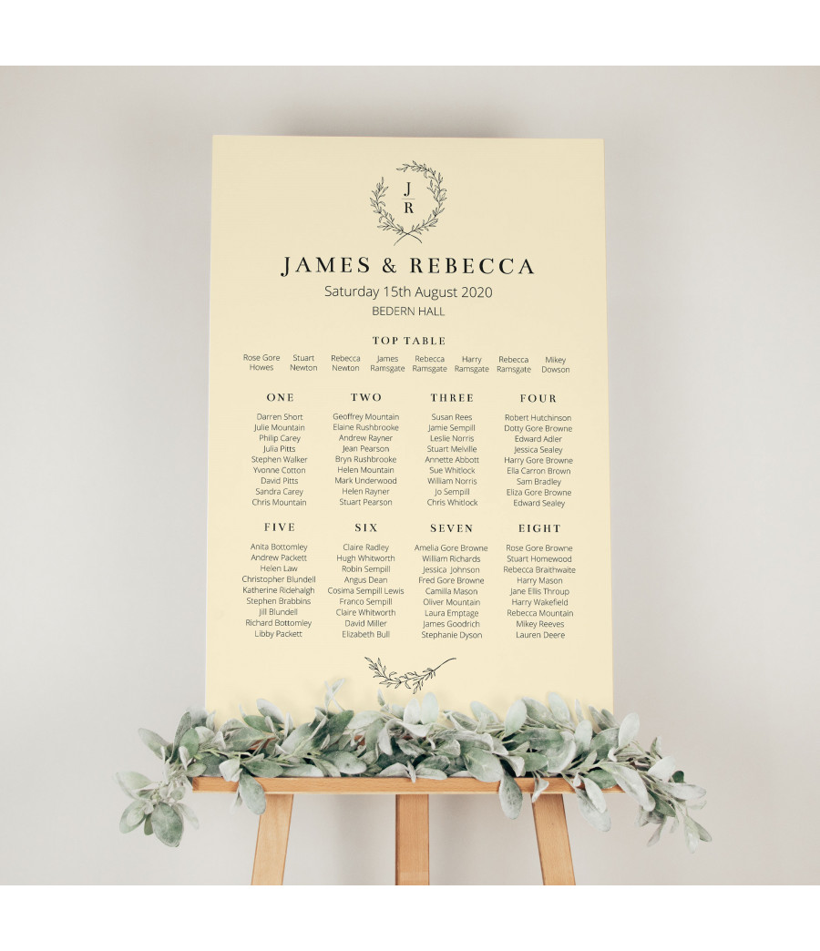 Cream wedding table plan with personalised guest seating and elegant wreath monogram design for wedding reception display