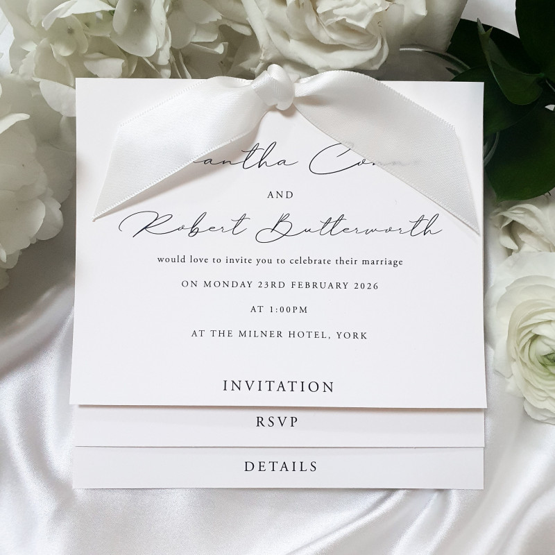 Elegant ivory wedding invitation with cream satin ribbon and luxury pearl card