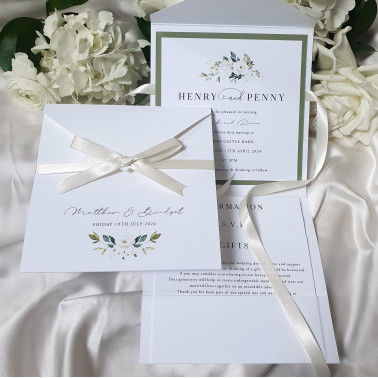 Luxury floral wedding stationery set featuring white roses and soft satin ribbon presentation finish