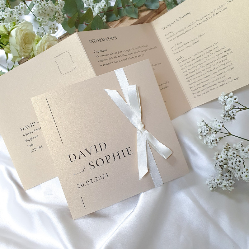 Personalised champagne and cream concertina wedding invitation finished with an elegant cream ribbon.