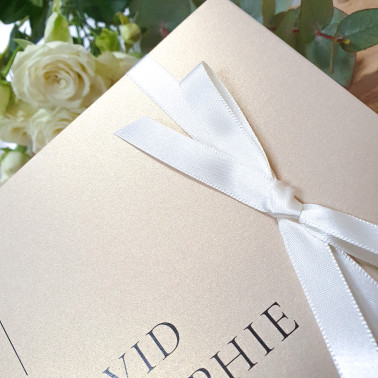 Elegant cream and champagne wedding invitation personalised with the couple’s names and wedding details.
