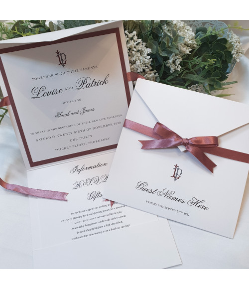 Luxury dusky pink day wedding invitation with personalised monogram and satin ribbon.