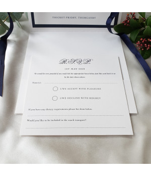 Close-up of premium navy blue wedding invitation with textured card and personalised guest names
